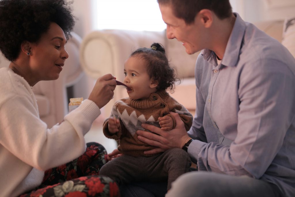 parents feeding their toddler